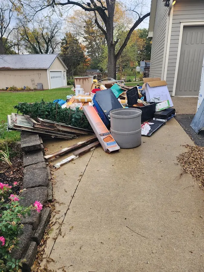 Dumpster being loaded with debris for Estate Cleanout Dumpster Rental in St. Simons